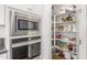 Walk-in pantry boasts ample shelving, providing plenty of storage space next to built-in oven and microwave at 23042 E Excelsior Ave, Queen Creek, AZ 85142