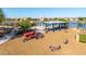 Fun community playground including a tractor and animal rockers near a lake and a covered seating area at 23042 E Excelsior Ave, Queen Creek, AZ 85142