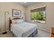 Bright bedroom with a large window, neutral walls, and a comfortable bed frame at 26484 W Mohawk Ln, Buckeye, AZ 85396