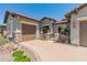 Charming exterior of a home with a gated courtyard and three-car garage at 26484 W Mohawk Ln, Buckeye, AZ 85396