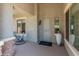 Inviting covered front porch with a sitting area and a 'hello' door mat at 26484 W Mohawk Ln, Buckeye, AZ 85396