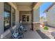 Cozy covered front porch featuring rocking chairs and desert landscaping at 26484 W Mohawk Ln, Buckeye, AZ 85396