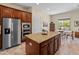 Spacious kitchen featuring stainless steel appliances, central island, granite countertops, and tile flooring at 26484 W Mohawk Ln, Buckeye, AZ 85396