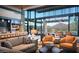 Spacious living room featuring stylish furnishings, floor-to-ceiling windows, and views of the golf course and mountains at 26484 W Mohawk Ln, Buckeye, AZ 85396