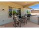Covered outdoor patio with a dining table and chairs for enjoying meals outside at 26484 W Mohawk Ln, Buckeye, AZ 85396