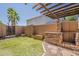 Outdoor kitchen with BBQ and pergola, set in a manicured backyard space with artificial grass and desert landscaping at 3282 S Warner Dr, Apache Junction, AZ 85120