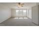 Spacious bedroom with neutral carpet, ceiling fan, natural light from multiple windows, and sliding-door closet at 3282 S Warner Dr, Apache Junction, AZ 85120