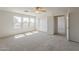 Bright bedroom with neutral carpet, ceiling fan, multiple windows, and sliding-door closet at 3282 S Warner Dr, Apache Junction, AZ 85120