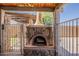 Outdoor stone fireplace and oven under a wooden beamed pergola, perfect for outdoor cooking at 3282 S Warner Dr, Apache Junction, AZ 85120