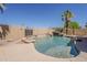 Backyard pool with a stone waterfall feature, tanning shelf, and desert landscaping creates a serene outdoor retreat at 3282 S Warner Dr, Apache Junction, AZ 85120