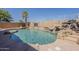 Inviting backyard pool with rocky slide and waterfall feature, surrounded by palm trees at 3282 S Warner Dr, Apache Junction, AZ 85120
