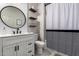 Well-lit bathroom featuring a modern vanity, round mirror, and stylish fixtures at 3715 S 57Th Ln, Phoenix, AZ 85043