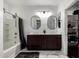 Bathroom featuring double sinks, dark cabinets, a bathtub, and walk in closet at 3715 S 57Th Ln, Phoenix, AZ 85043