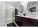 Bright bathroom featuring double sinks, dark cabinets, and bathtub at 3715 S 57Th Ln, Phoenix, AZ 85043