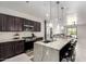Kitchen with granite island, pendant lights, dark cabinets, and stainless appliances at 3715 S 57Th Ln, Phoenix, AZ 85043