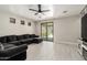 Open living room features tile floors, a ceiling fan, and sliding door to the backyard at 3715 S 57Th Ln, Phoenix, AZ 85043