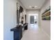 Elegant entry hall with console table art display leading to a modern front door at 37200 N Cave Creek Rd # 1045, Scottsdale, AZ 85262