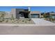 Contemporary home featuring desert landscaping, stone accents, and a modern glass-paned garage door at 37200 N Cave Creek Rd # 1045, Scottsdale, AZ 85262