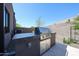 Outdoor kitchen features a stainless steel grill with stone counter and a brick privacy wall, perfect for entertaining guests at 37200 N Cave Creek Rd # 1045, Scottsdale, AZ 85262
