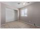 A bedroom with tile flooring, a ceiling fan, a closet, and a window at 3722 W Hadley St, Phoenix, AZ 85009