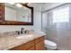 Bathroom featuring a granite countertop, decorative mirror, and glass-enclosed shower at 4330 E Desert Trumpet Rd, Phoenix, AZ 85044