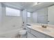 Bright bathroom featuring a shower-tub combo with tiled walls and a vanity with solid surface countertops at 4330 E Desert Trumpet Rd, Phoenix, AZ 85044