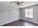 Minimal bedroom with hardwood floors, a ceiling fan, and a window providing natural light at 4330 E Desert Trumpet Rd, Phoenix, AZ 85044
