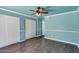Light blue bedroom with hardwood floors, ceiling fan, and spacious closet at 4330 E Desert Trumpet Rd, Phoenix, AZ 85044
