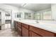 Bathroom with double sinks, wood cabinets, and a large mirror at 43581 W Mccord Dr, Maricopa, AZ 85138