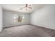 Bright, carpeted bedroom with a ceiling fan and views of the backyard at 43581 W Mccord Dr, Maricopa, AZ 85138