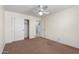 Bedroom features neutral walls, carpet, a ceiling fan, and a closet at 43581 W Mccord Dr, Maricopa, AZ 85138