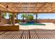 Backyard view of the pool and waterfall feature under a covered patio with palm trees at 43581 W Mccord Dr, Maricopa, AZ 85138