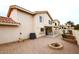 A backyard with gravel, a small garden area, a fountain, and a covered patio attached to the beige two-story home at 4437 E Villa Theresa Dr, Phoenix, AZ 85032