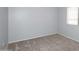 A simple bedroom with neutral carpet and gray walls, featuring a window with blinds at 4437 E Villa Theresa Dr, Phoenix, AZ 85032
