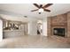 Open-concept living area with brick fireplace, ceiling fan, tile floor, and a view to the kitchen and stairs at 4437 E Villa Theresa Dr, Phoenix, AZ 85032
