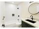 Modern bathroom featuring a subway-tiled shower, a round mirror, and stylish fixtures at 4611 E Fremont St, Phoenix, AZ 85042