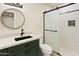 Updated bathroom with stylish vanity, modern lighting, round mirror, and walk-in shower with glass door at 4611 E Fremont St, Phoenix, AZ 85042
