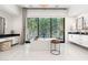 Bright bathroom featuring a modern soaking tub set beneath a large window with a view of lush greenery at 4708 N 41St Pl, Phoenix, AZ 85018