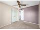 Bedroom with a ceiling fan, closet, neutral carpet, and two-tone paint at 4740 W Bloomfield Rd, Glendale, AZ 85304
