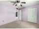 Bedroom with a ceiling fan, closet, neutral carpet, and light purple walls at 4740 W Bloomfield Rd, Glendale, AZ 85304