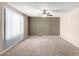 Living room with neutral walls, tiled floor, a ceiling fan, and large window to allow natural light at 4740 W Bloomfield Rd, Glendale, AZ 85304