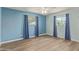 Bright bedroom with hardwood floors, two windows with curtains, and fresh paint at 5204 E Colby St, Mesa, AZ 85205