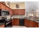 Well-lit kitchen featuring granite counters, stainless steel appliances, and wooden cabinetry at 5524 E Garnet Cir, Mesa, AZ 85206
