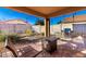 Cozy covered patio with outdoor seating, desert plants, and a brick-paved area for entertaining at 5524 E Garnet Cir, Mesa, AZ 85206