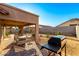 Relaxing covered patio with a swing, BBQ grill, and desert landscaping for outdoor enjoyment at 5524 E Garnet Cir, Mesa, AZ 85206
