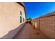 Side yard featuring a brick paver walkway, desert landscaping, and a view of the backyard privacy wall at 5524 E Garnet Cir, Mesa, AZ 85206