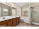 Bathroom featuring double sinks, a tub, a separate shower, and a bright window at 6317 E Colby St, Mesa, AZ 85205