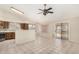 Open-concept living area with kitchen featuring brown cabinets, stainless appliances, and a tile backsplash at 6317 E Colby St, Mesa, AZ 85205