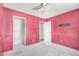 A view of the bedroom with pink walls, closet, and a door at 6426 W Mulberry Dr, Phoenix, AZ 85033