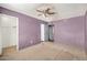 A view of the bedroom with purple walls and a ceiling fan at 6426 W Mulberry Dr, Phoenix, AZ 85033